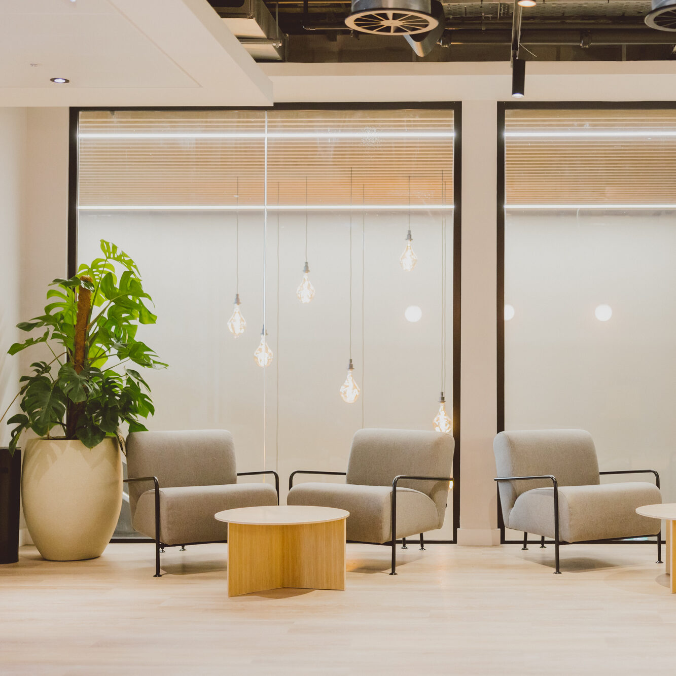 Modern lounge seating at 10X Brindleyplace, event space in Birmingham, with armchairs, round table and pendant lights, ideal for breakout conversations.