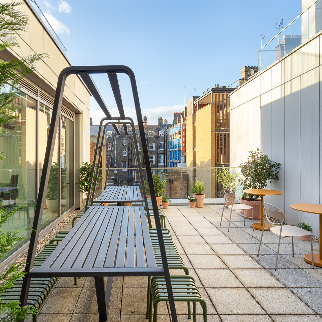 Outdoor terrace area in coworking space in Putney, featuring modern seating, potted greenery, and views of surrounding buildings.