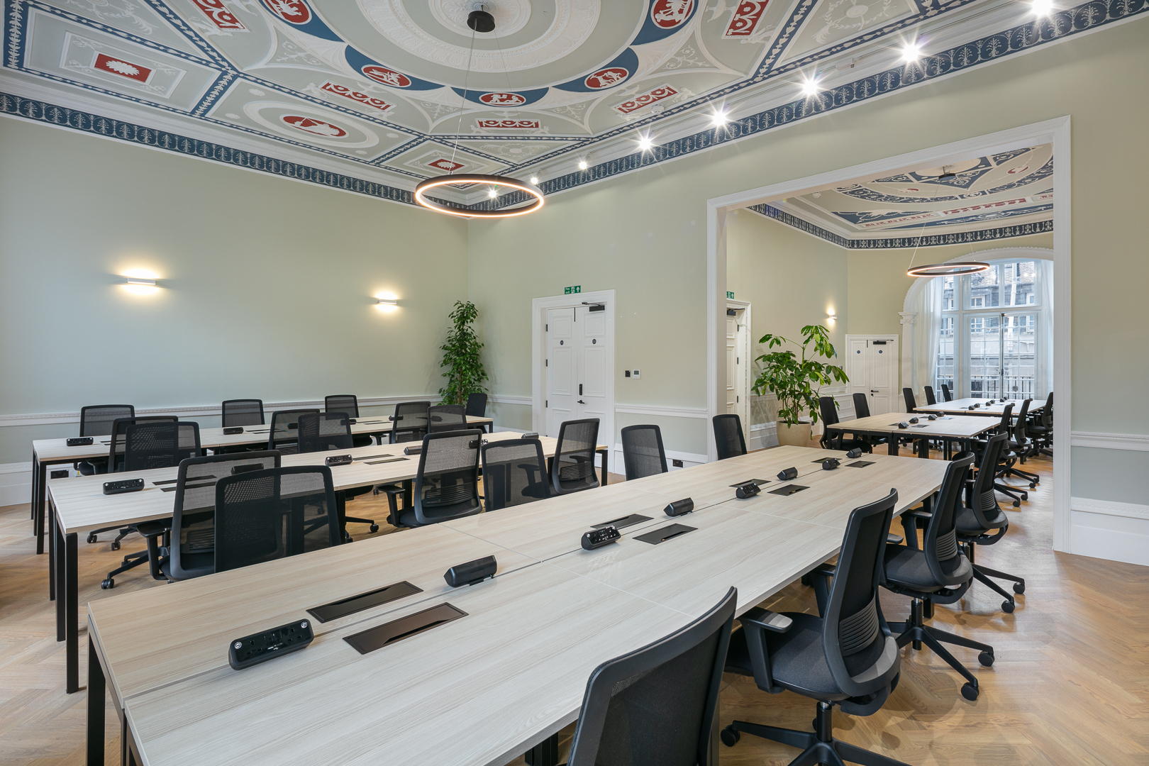 Elegant private office space for large teams in Marylebone, featuring multiple desks with ergonomic chairs, built-in power outlets, soft lighting, and boutique-style decor — a fully serviced workspace ideal for expanding businesses.