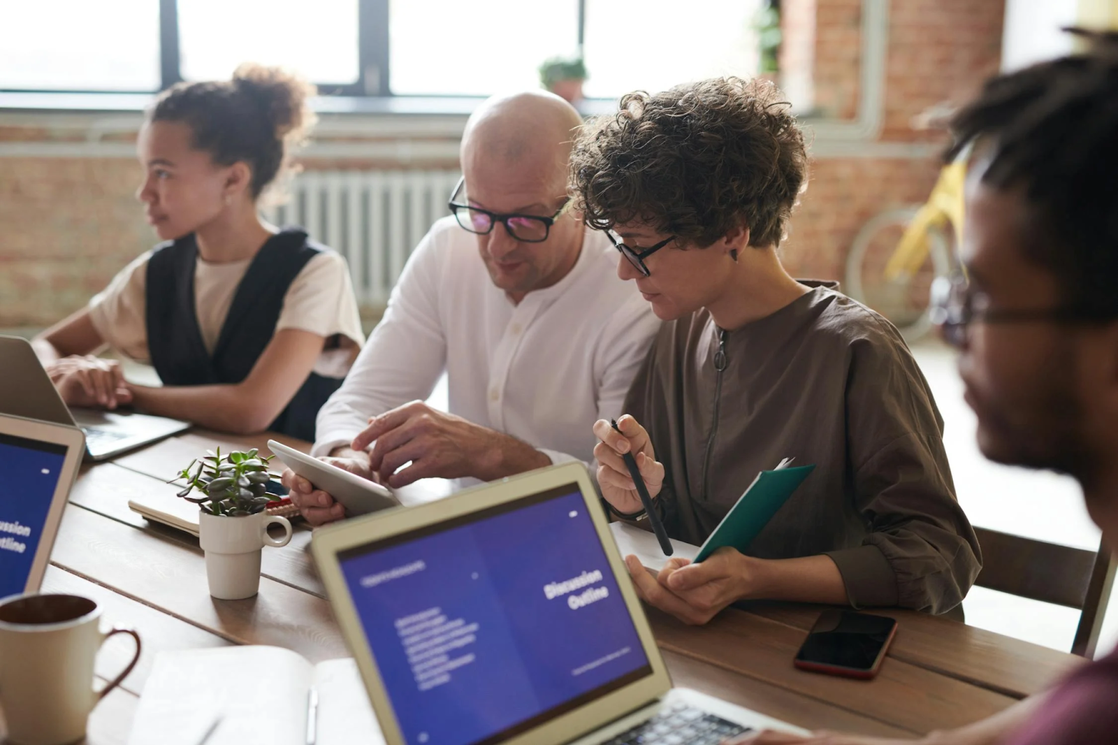 Image of three people having a meeting, taking advantage of networking opportunities in a co-working space. Taken from Pexels