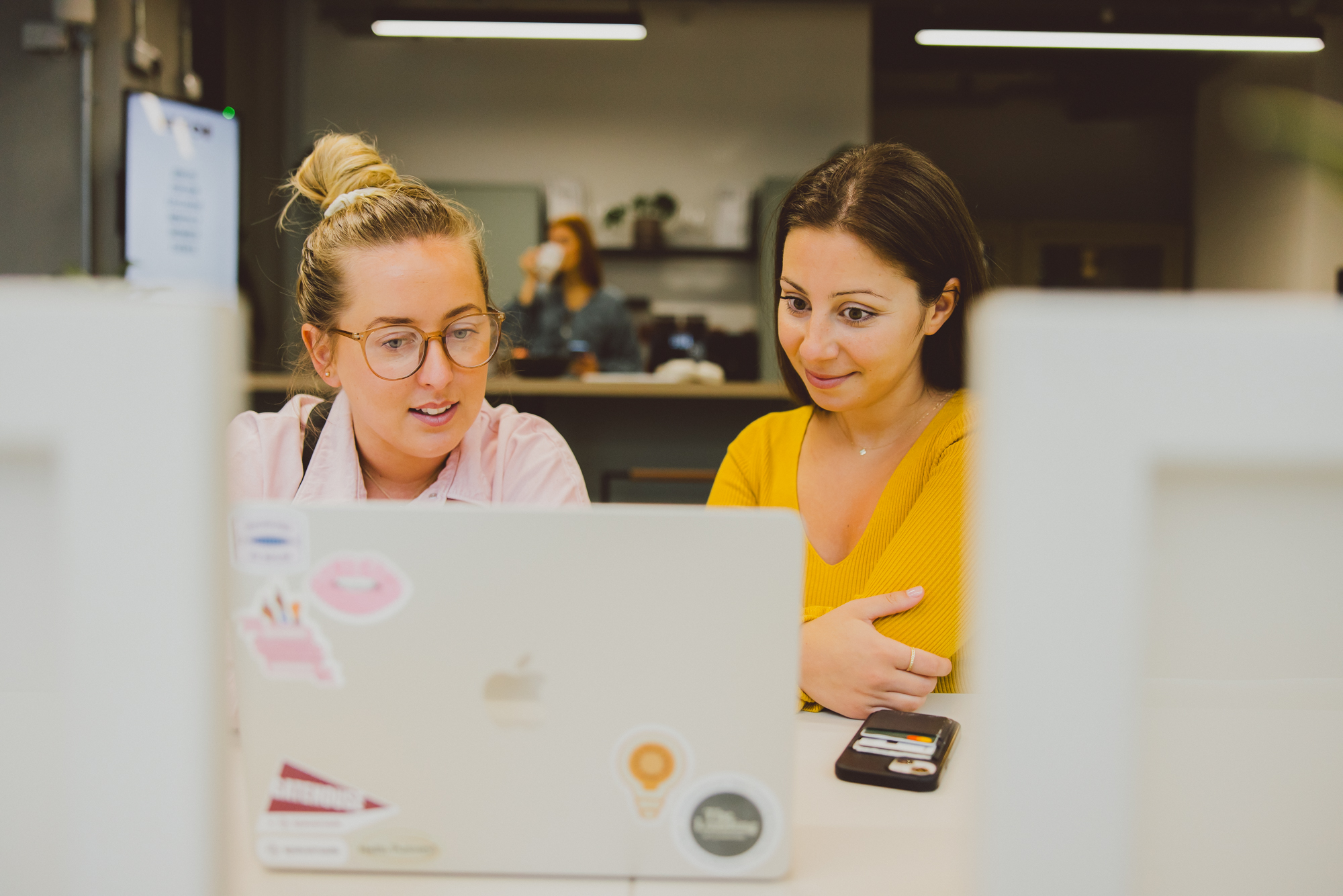 Two woman looking at the laptop screen and sharing ideas and opinions.