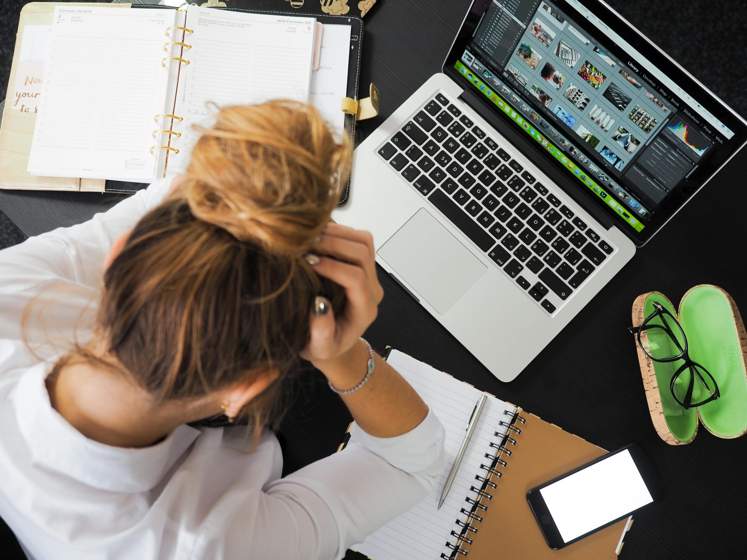 woman working at a desk with her head in her hands